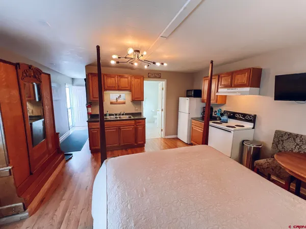 a kitchen with stainless steel appliances a refrigerator and wooden floor