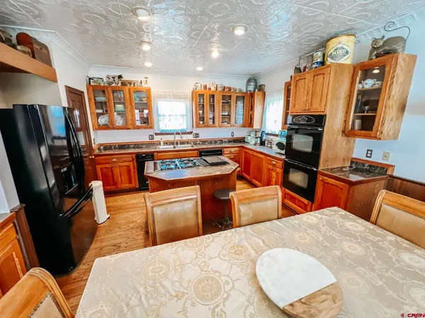 a kitchen with stainless steel appliances granite countertop a stove a sink dishwasher and a refrigerator with wooden floor