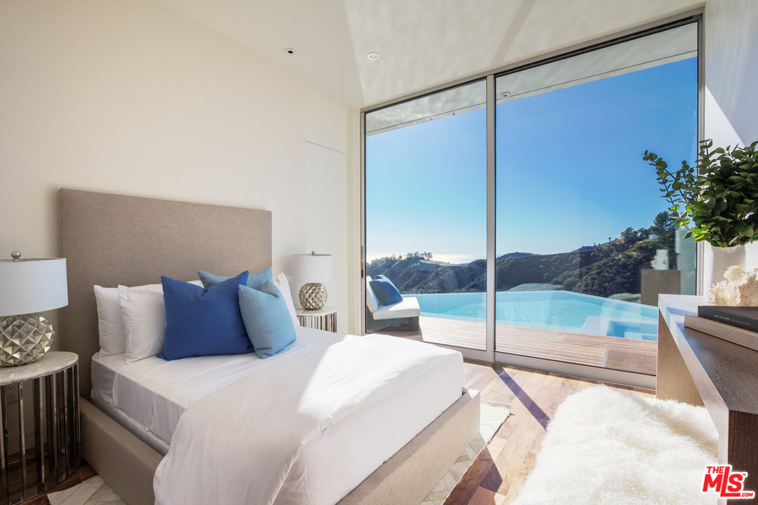 1979 Stradella Road Los Angeles, CA 90077 - Photo 22 of 38 a bedroom with a large bed and a balcony view