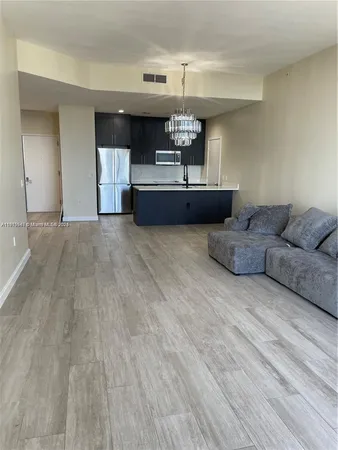a living room with furniture and kitchen view