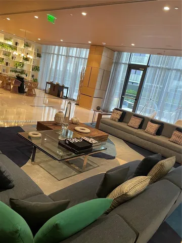 a living room with furniture and large windows