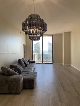 a living room with furniture a chandelier and a window