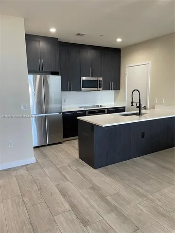 a kitchen with stainless steel appliances granite countertop a sink a stove a refrigerator and cabinets