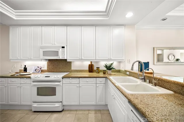 a kitchen with granite countertop a sink a stove and cabinets