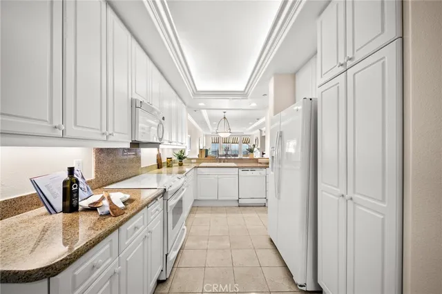 a kitchen with stainless steel appliances granite countertop a refrigerator a sink dishwasher a stove with white cabinets