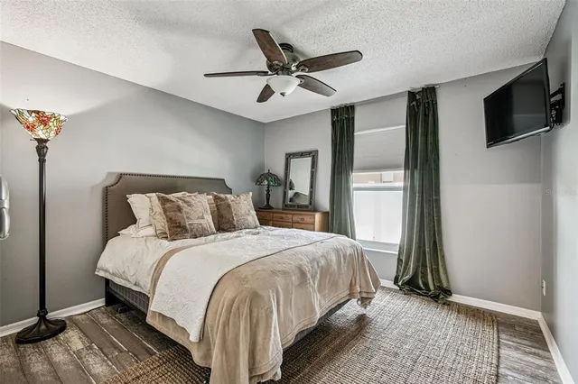 a living room with furniture a flat screen tv and a floor to ceiling window