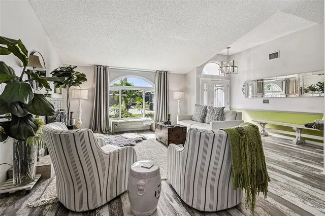 a living room with furniture fireplace and large windows