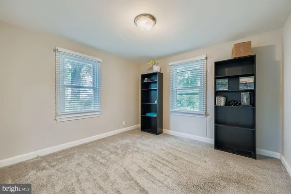 a view of an empty room with closet and a window