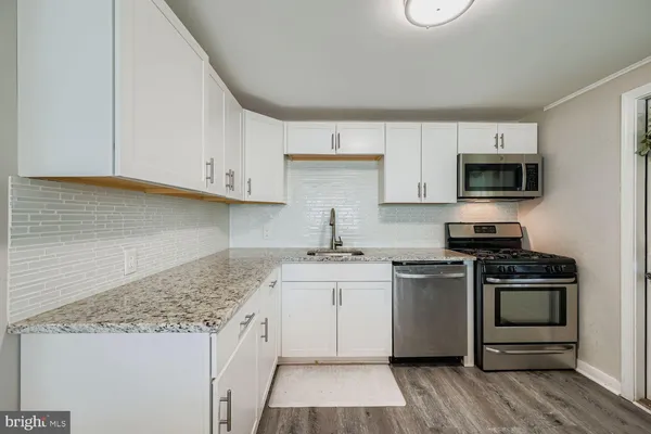 a kitchen with stainless steel appliances granite countertop a stove a sink and a microwave