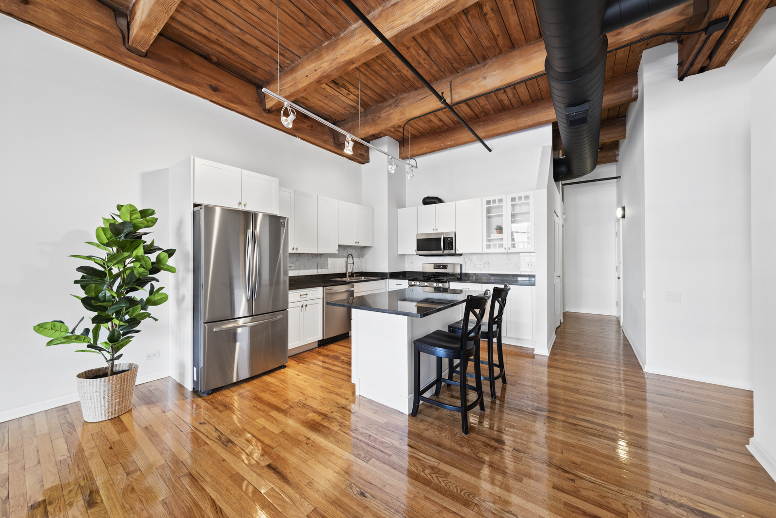 1017 West Washington Boulevard, Unit 5B Chicago, IL 60607 - Photo 6 of 13 a kitchen with stainless steel appliances a dining table chairs refrigerator and stove