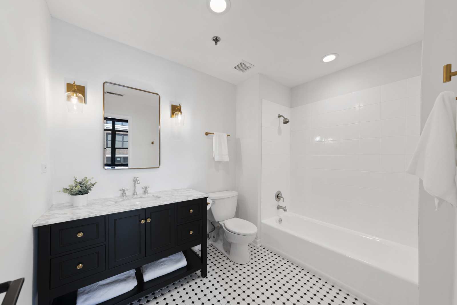 1017 West Washington Boulevard, Unit 5B Chicago, IL 60607 - Photo 9 of 13 a bathroom with a double vanity sink toilet mirror and bathtub