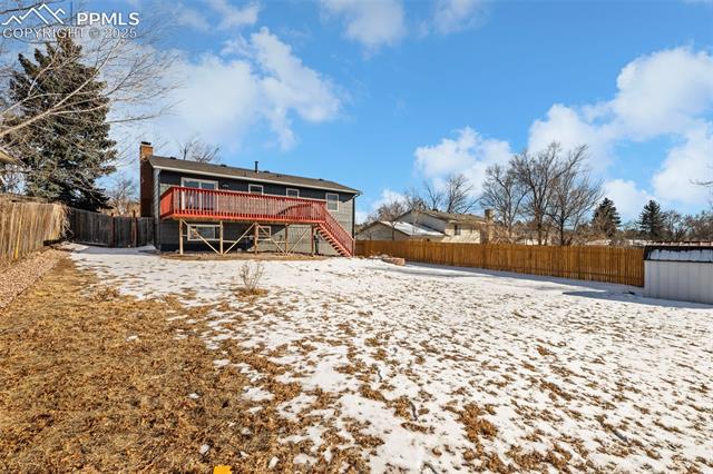 6319 Chippewa Road Colorado Springs, CO 80915 - Photo 8 of 36 Snow covered rear of property featuring a wooden deck