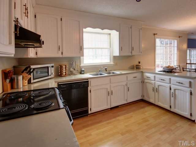 8704 Oneal Road Raleigh, NC 27613 - Photo 4 of 12 Large kitchen with tons of counter space and cabinets for storage. The bar area makes a great spot for serving or a quick meal. Window overlooks huge backyard. Black appliances and hardwood floors!