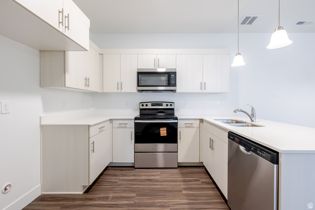 709 West 4500th South, Unit N301 Mapleton, UT 84664 - Photo 11 of 17 Kitchen with stainless steel appliances, a peninsula, dark wood-type flooring, pendant lighting, and white cabinetry