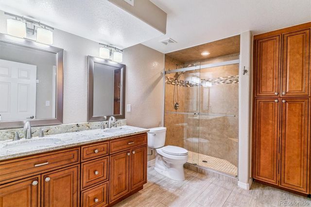 a bathroom with a granite countertop sink toilet and shower
