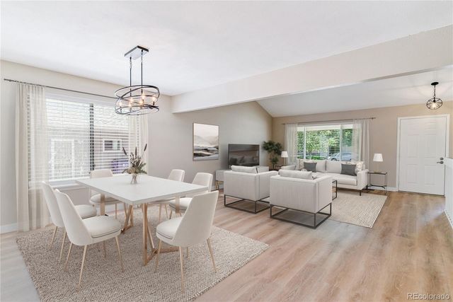 a view of a dining room with furniture a chandelier and wooden floor