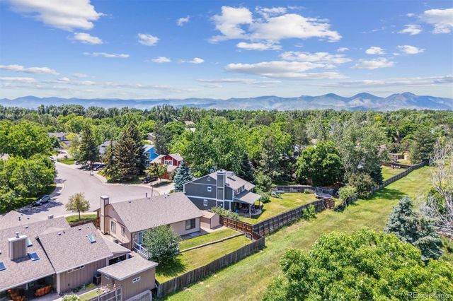 an aerial view of a city with lots of residential buildings and mountain view in back