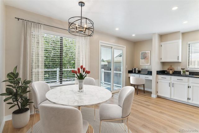 a dining room with furniture a chandelier and wooden floor