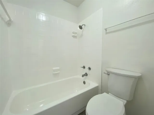 a white toilet sitting next to a bath tub