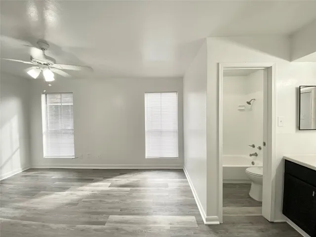 a view of an empty room with a fireplace and a window