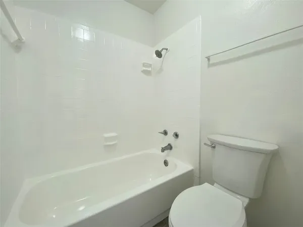 a white toilet sitting next to a bath tub
