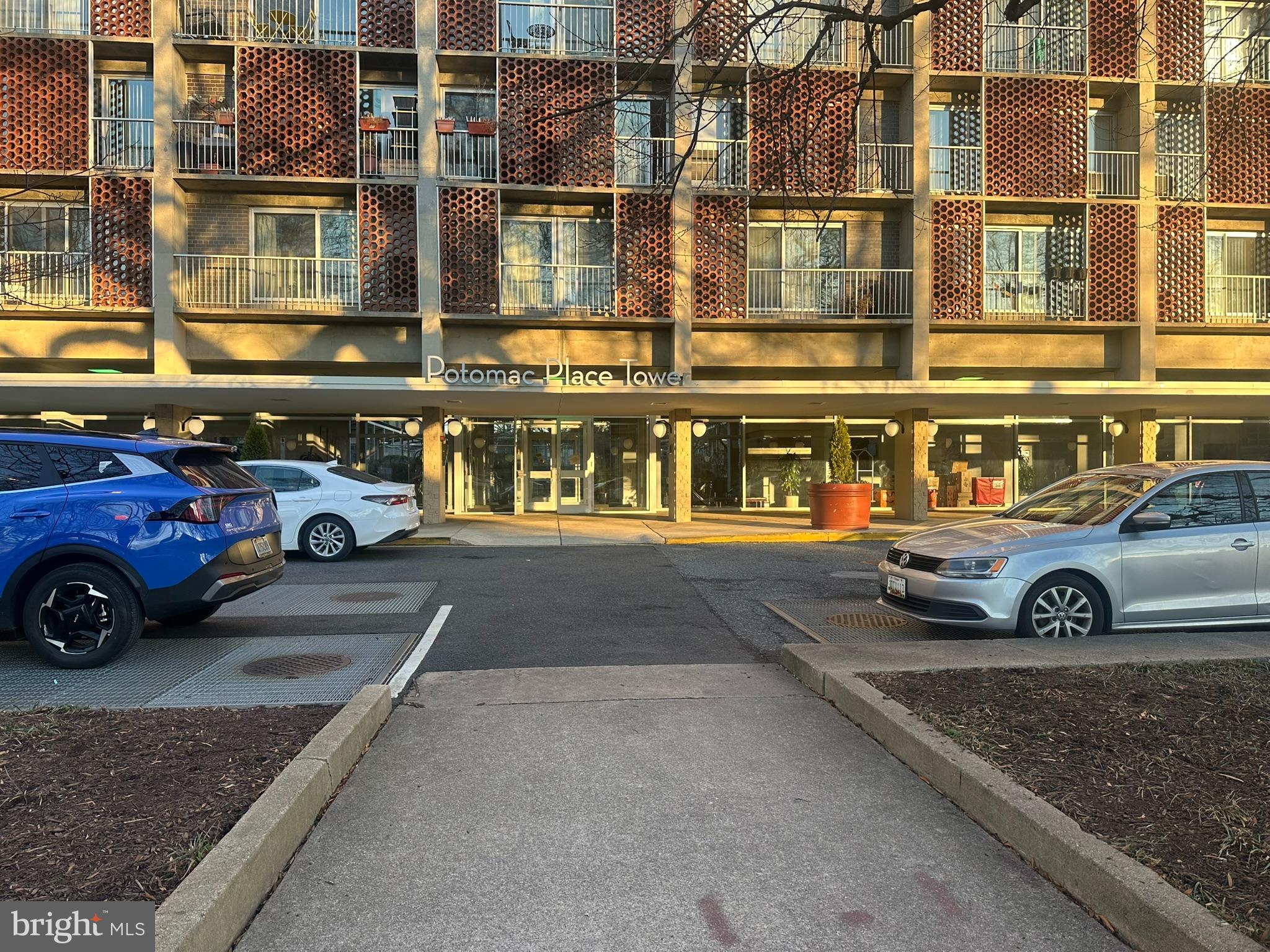 a front view of a residential apartment building with a parking area