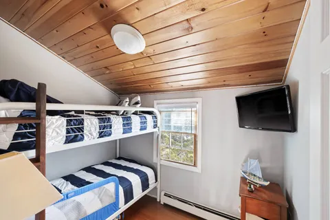 a view of a patio with couches table and chairs under an umbrella with wooden floor