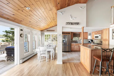a living room with furniture a flat screen tv and floor to ceiling window