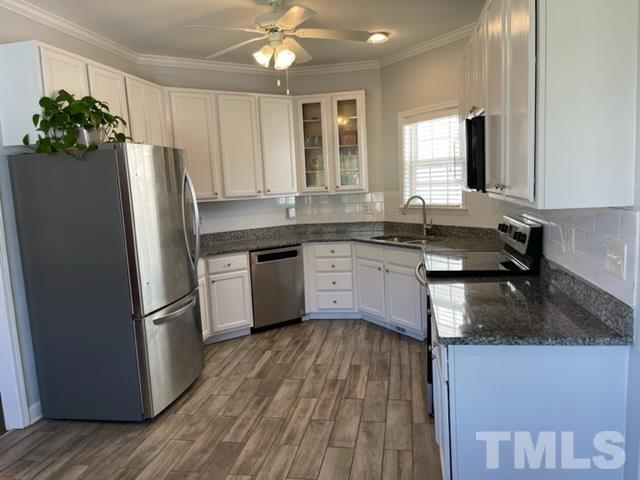 4420 Major Loring Way Raleigh, NC 27616 - Photo 8 of 26 a kitchen with stainless steel appliances granite countertop a refrigerator a sink dishwasher a stove and white countertops with wooden floor