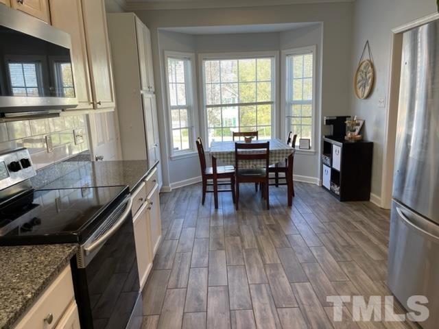 4420 Major Loring Way Raleigh, NC 27616 - Photo 9 of 26 a kitchen with a wooden floor and a dining table