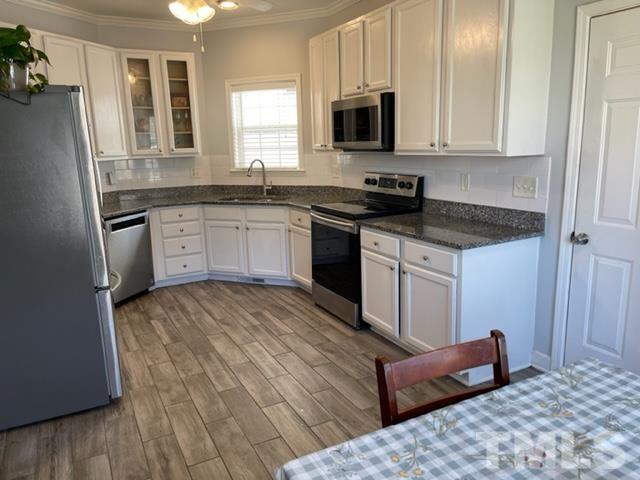 4420 Major Loring Way Raleigh, NC 27616 - Photo 10 of 26 a kitchen with stainless steel appliances granite countertop a stove a sink and a microwave