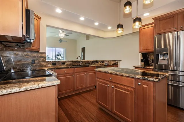 a kitchen with stainless steel appliances granite countertop sink stove top oven and cabinets