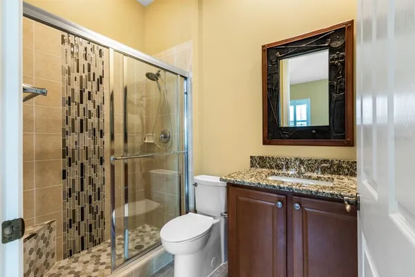 a bathroom with a granite countertop sink toilet and shower