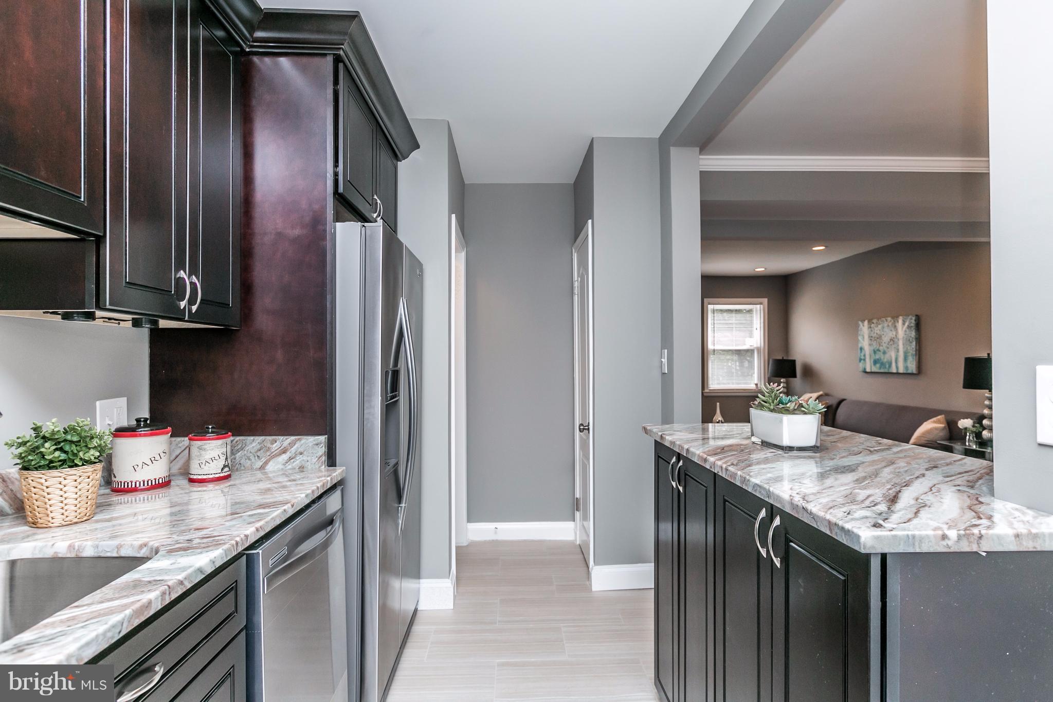 4674 Marble Hall Road Baltimore, MD 21239 - Photo 3 of 29 a kitchen with granite countertop kitchen island stainless steel appliances a sink stove and cabinets