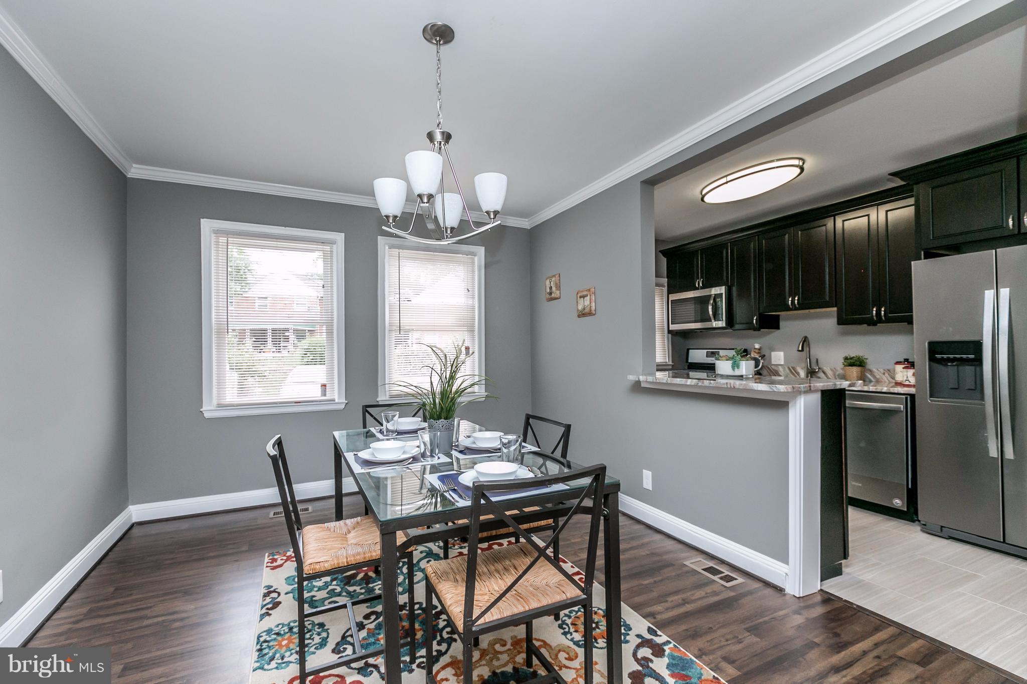 4674 Marble Hall Road Baltimore, MD 21239 - Photo 5 of 29 a view of a dining room with furniture a chandelier and wooden floor