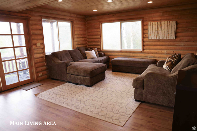 15253 Mill Road, Unit 62 Huntsville, UT 84317 - Photo 13 of 48 Living area featuring log walls, wood-finish flooring, a wood-paneled ceiling, recessed lighting, and multiple windows