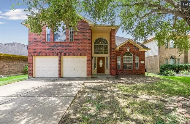 a front view of a house with a garden and yard
