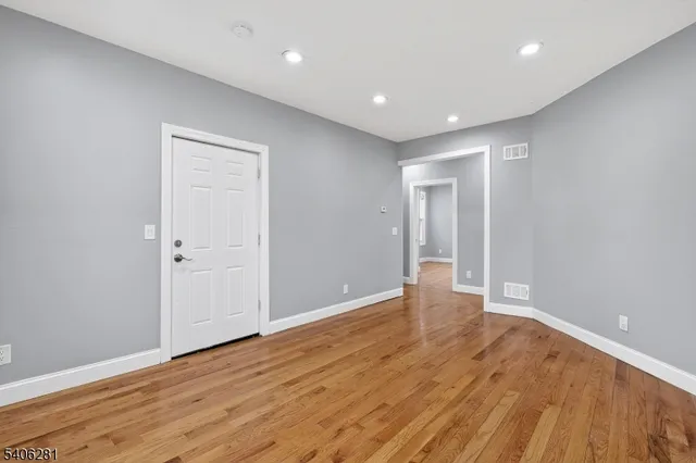 a view of an empty room with wooden floor
