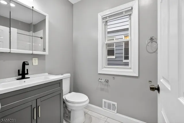 a bathroom with a sink a toilet and a window