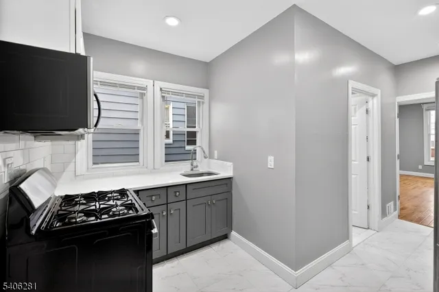 a kitchen with a stove and a flat screen tv