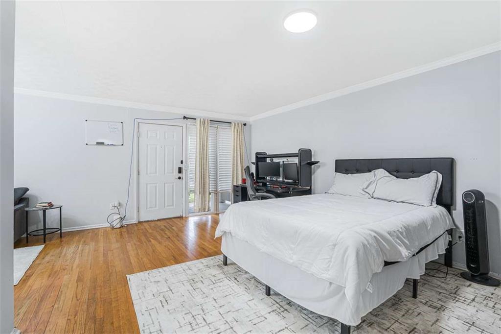 1150 Collier Road Northwest, Unit 25D Atlanta, GA 30318 - Photo 14 of 21 a spacious bedroom with a bed and a wooden floor