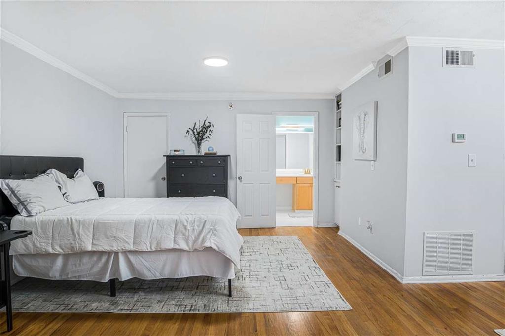 1150 Collier Road Northwest, Unit 25D Atlanta, GA 30318 - Photo 4 of 21 a bedroom with a bed and wooden floor