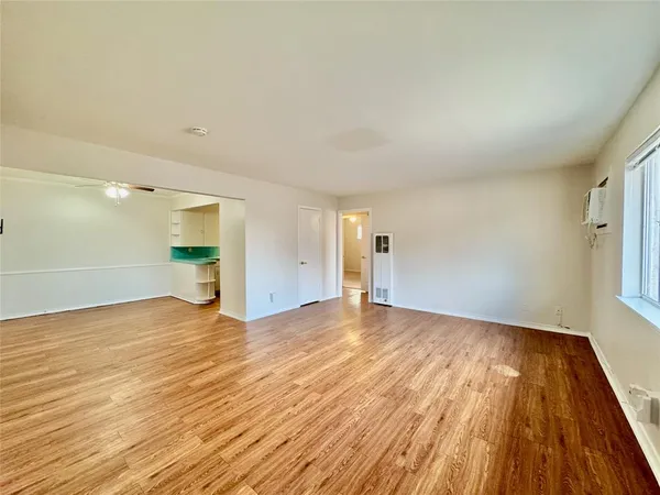 a view of empty room with wooden floor