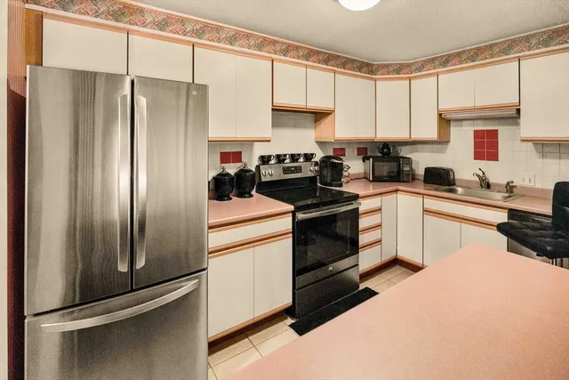 a kitchen with a refrigerator sink and cabinets
