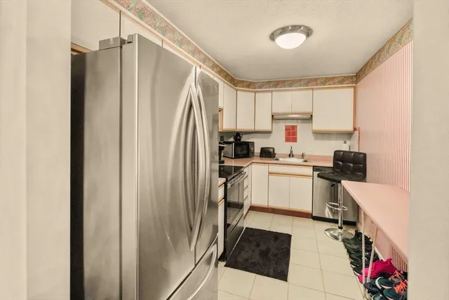 a kitchen with white cabinets and white appliances