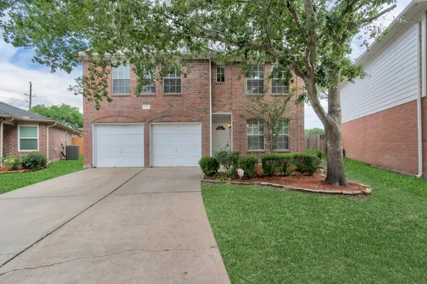 a front view of a house with a yard and an trees