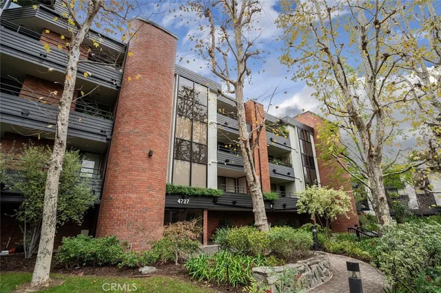 front view of a brick house with a small yard and plants