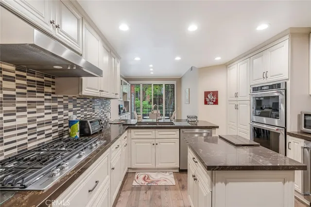 a kitchen with granite countertop a sink and stainless steel appliances