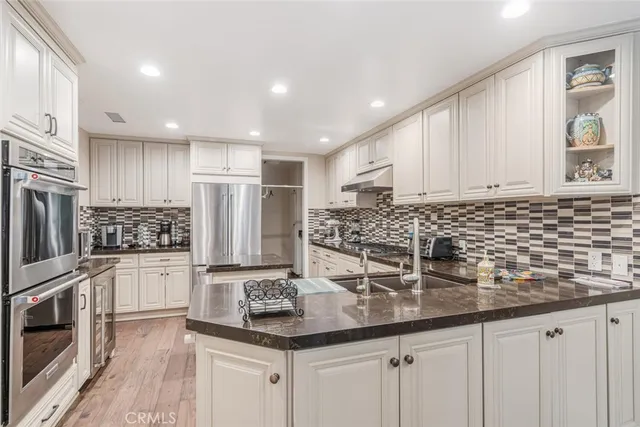 a kitchen with white cabinets and stainless steel appliances