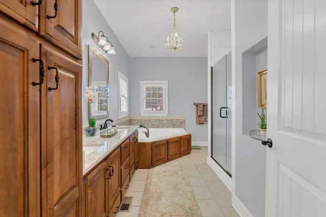 a spacious bathroom with a tub sink and mirror